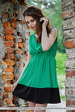 Loretta strips her green sexy flowing dress and flaunts her lean, nubile body and delectable pussy by the brick wall ruins.